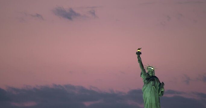 Statue of Liberty with Lights on and Pink Sky