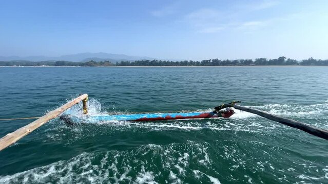 Close up shot of oars of traditional fishing boat at ocean, mountain in the horizon Goa in India 4K