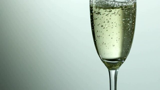 Animation of confetti falling over champagne glass