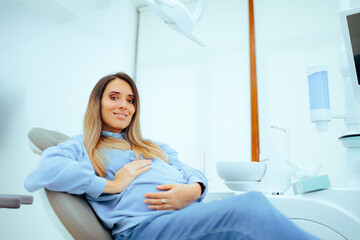 Pregnant Woman Sitting in a Dental Chair for Regular Appointment. Cheerful mother to be ready for a...