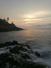 Long exposure of sunset view on a rocky beach in East Java, Indonesia.