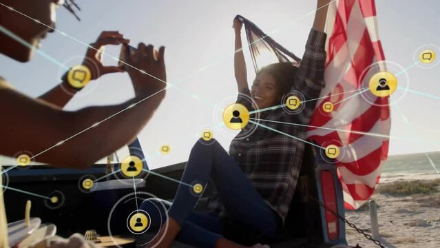 Animation of network of connections with icons over diverse couple in car by sea