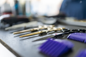 Raw of different scissors on a board in a barber shop - obrazy, fototapety, plakaty