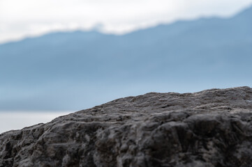 A large stone against a background of mountains. Bluish silhouettes of foggy mountains. Selective...