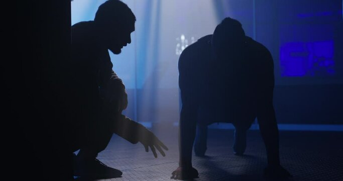 Man, personal trainer and push ups at night for training, exercise or workout routine at gym. Male person, athlete or bodybuilder with coach or mentor for muscle gain, strength or endurance at club