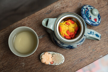 Flower Chinese Tea in Hot Teapot And Teacups On Wooden Table. Top view.