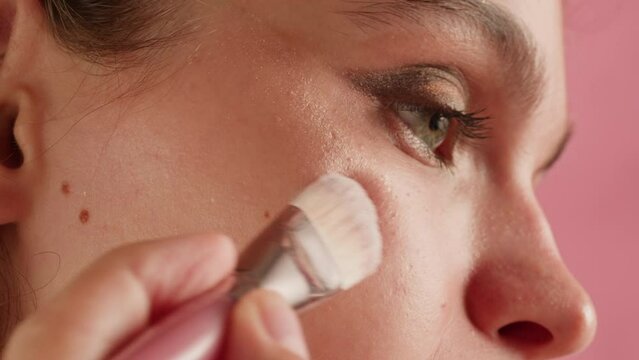 Beauty shot of woman applying foundation bb cream on previously applied moisturizing face lotion and smiling in camera. Concept of skincare, cosmetics, make up, beauty