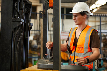 male factory worker control and holding steering wheel on forklift truck