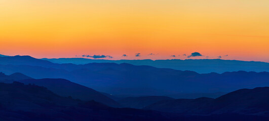 Panorama of layers of mountains at sunset, sunrise 