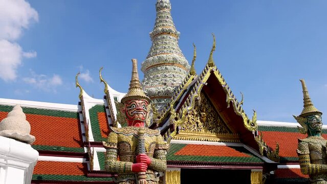 Giant demon statues and intricate architecture of Wat Phra Kaew temple in Bangkok, Thailand.