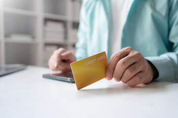 Man making financial transaction using credit card and smartphone. Young man paying online, using banking service, entering information, shopping, ordering in internet store, doing secure payment.