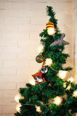 beautifully decorated Christmas tree against a backdrop of a white brick wall