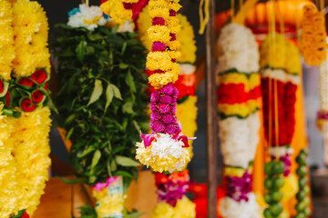 Yellow and pink flowers for Indian holiday. Beautiful necklaces made of natural flowers at the Indian market.
