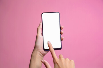 Female hands holding modern cellphone with blank screen for mockup and pointing with finger at screen