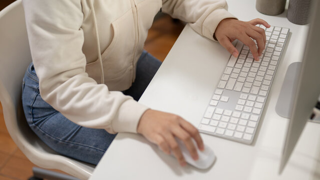 Close-up image of a female office employee or college student is working on her computer at her desk