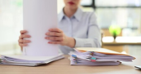 Lady employee puts created folders with documents into stack