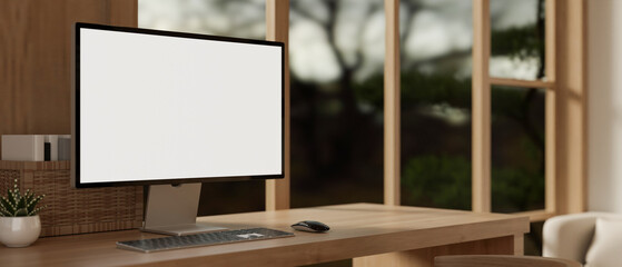 A white-screen PC computer mockup on a hardwood table in a cosy, modern room. Home workspace
