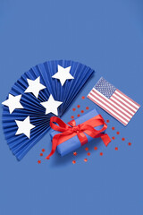 Gift box with USA flag and fan on blue background. American Independence Day