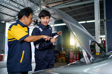 Senior professional repairman inspecting an oil engine in an old car.