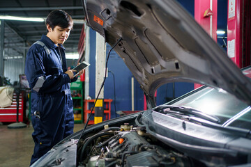 Professional Asian vehicle technician posing for photography in garage. 