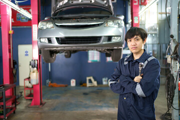 Professional Asian vehicle technician posing for photography in garage. 