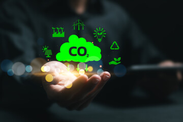 Businessman hold virtual carbon reduction icons for climate change to limit global warming and...