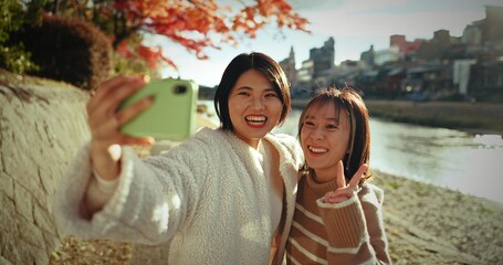 Japanese women, friends and happy in selfie, nature and lake with web blog, post and excited on...