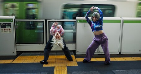 Asian woman, dancing and railway station by train for energy, art or underground performance in subway. Female person, friends or hip hop dancers in Japan, practice or training together by transport