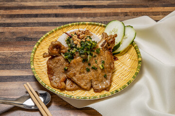 Pork chop curry with rice, cucumber and chopsticks served in dish isolated on wooden table top view of hong kong fast food