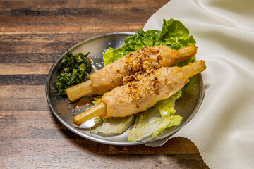 Vietnamese Sugar Cane with Shrimps with lettuce leaf and spring onion served in dish isolated on wooden table top view of hong kong fast food