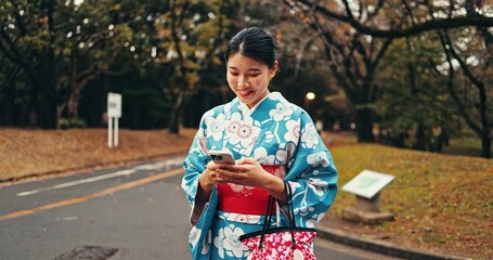 City, phone and Japanese woman in street for online networking, website and social media. Travel, walking and happy person typing on smartphone with traditional fashion, culture and kimono in nature