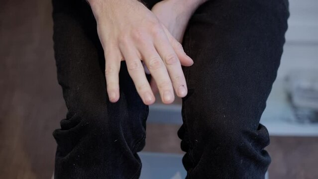 Close-up of Anxious Caucasian Man's Nervous Gestures and Shaking Hands