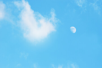 Naklejka na ściany i meble Light blue sky and white clouds and the moon. With copy space. 