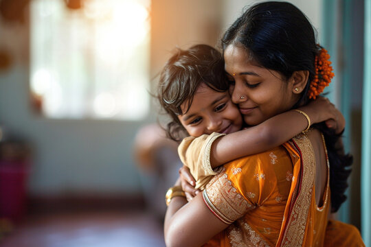 Moment of child hugging and embracing mom. Portrait of happy Indian American mommy and her child kid hugging each in apartment background. Mother's Day family holiday unconditional love concept.