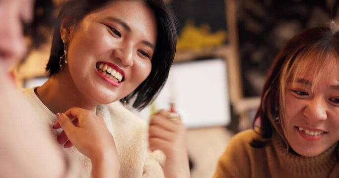 Japanese friends, laughing and talking in restaurant for dinner, vacation and funny joke with care indoors. Women, man and happy together on lunch in tokyo city and comedy for bonding in coffee shop