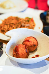 Takoyaki balls in a bowl with sauce.