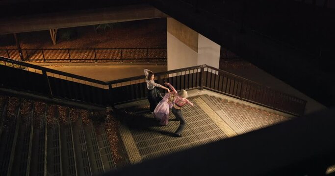 Women, group and dancing on steps in city, moving body and freedom for street performance in night. Team, dancer or people with art, concert and stairs with creativity, vision and balance in Tokyo