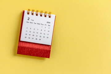 Desk calendar for February 2024 on a yellow background with copy space.