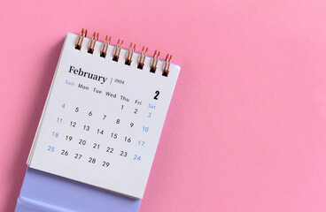 Desk calendar for February 2024 on a pink background with copy space. - obrazy, fototapety, plakaty
