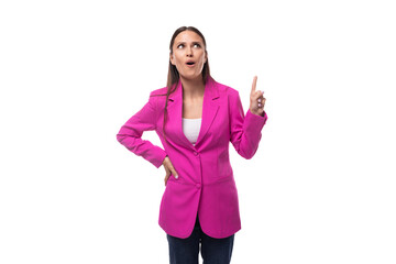 Obraz na płótnie Canvas young stylish business assistant woman dressed in a bright pink jacket points her hand to the side