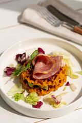 Sweet potato waffles with ham, avocado and salad