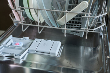 Dishwasher machine with dishwasher plates, close-up.