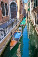 gondola at the pier at a narrow canal in Venice