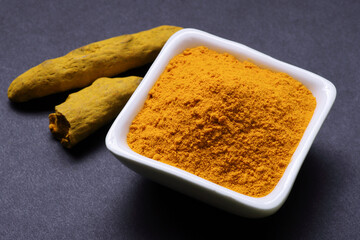 Indian Spice Turmeric powder in bowl isolated on Black background 