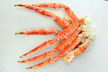 frosted Alaska king crab legs close up photo on white table background