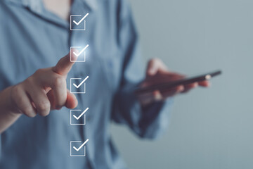 Businessman hand using smartphone and tick correct check mark for accept or approve request action. Checklist, Survey, Assessment, Term of service agreements and Personal Data Protection Act concept.