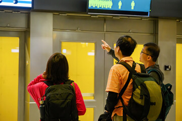 A group of tourists checking the information display board in the subway station