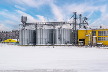 modern agro-processing plant for processing and silos for drying cleaning and storage of agricultural products, flour, cereals and grain in snow of winter field