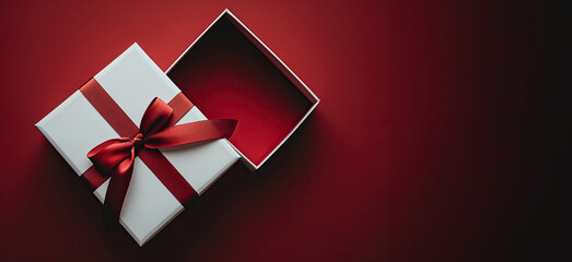 White gift box decorated with red ribbon with copy space