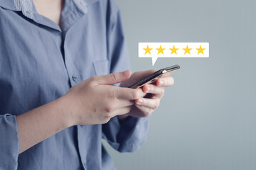 Customer using mobile smartphone for giving satisfaction score with five star excellent experience. Review the service with Best score. Customer Satisfaction survey and feedback rating concept.